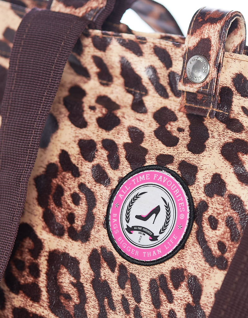 Close-up detail of leopard shopper with brand logo and handles