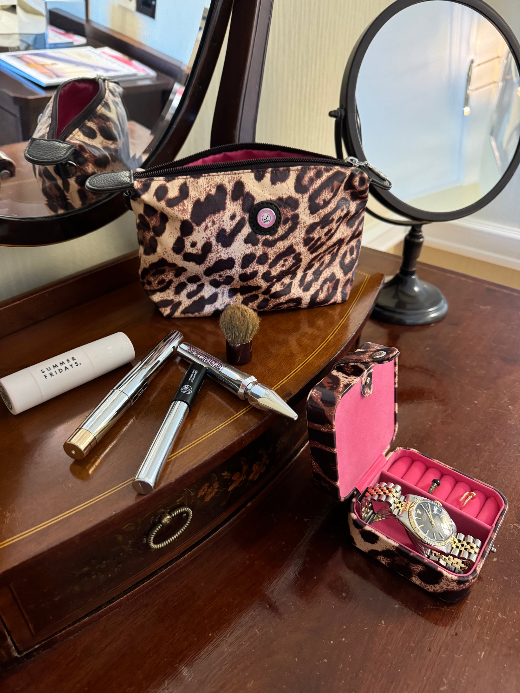 Make-up-Täschchen im Leoparden-Design auf dem Schminktisch neben Kosmetik und Schmuckkästchen