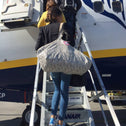 Frau mit großer Zebra-Shopper-Tasche beim Einsteigen ins Flugzeug