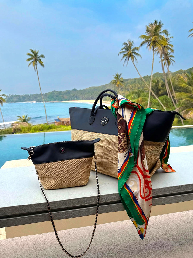 Tote bag and crossbody bag in black vegan leather and beige straw on a terrace with pool, palm trees and ocean view