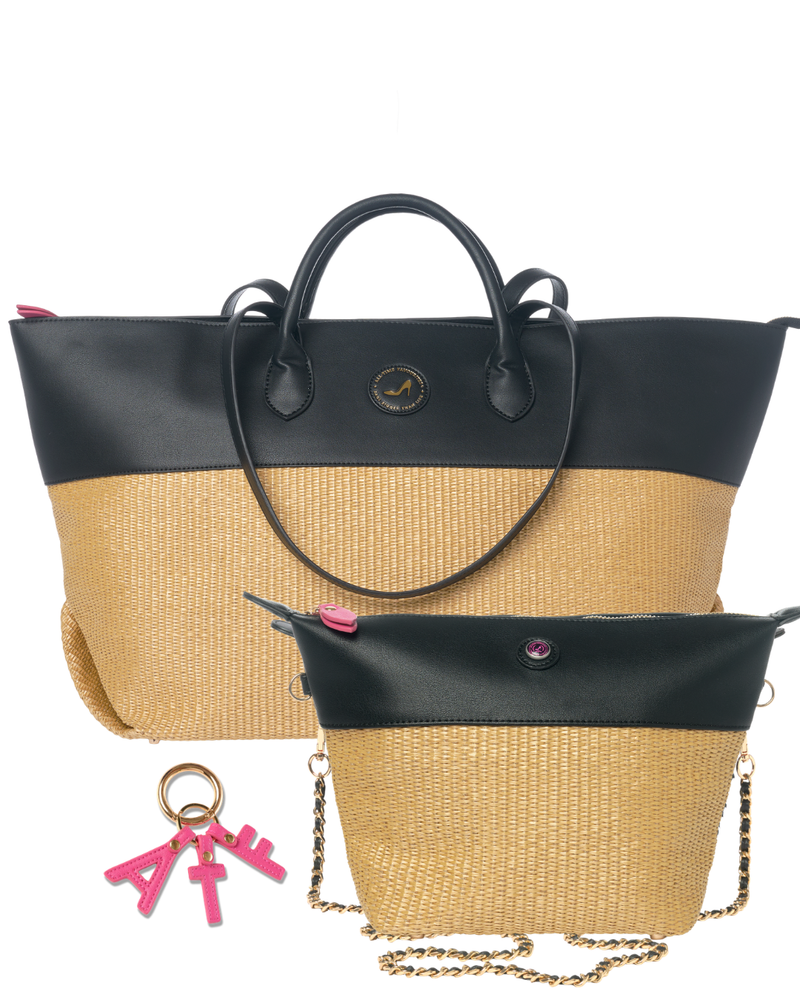 A two-tone tote bag with a black faux-leather top section and a natural beige woven straw bottom, shown alongside a matching zip pouch and a pink keychain on a white background.