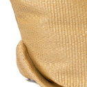 Close-up of a woven straw bag with protective metal studs