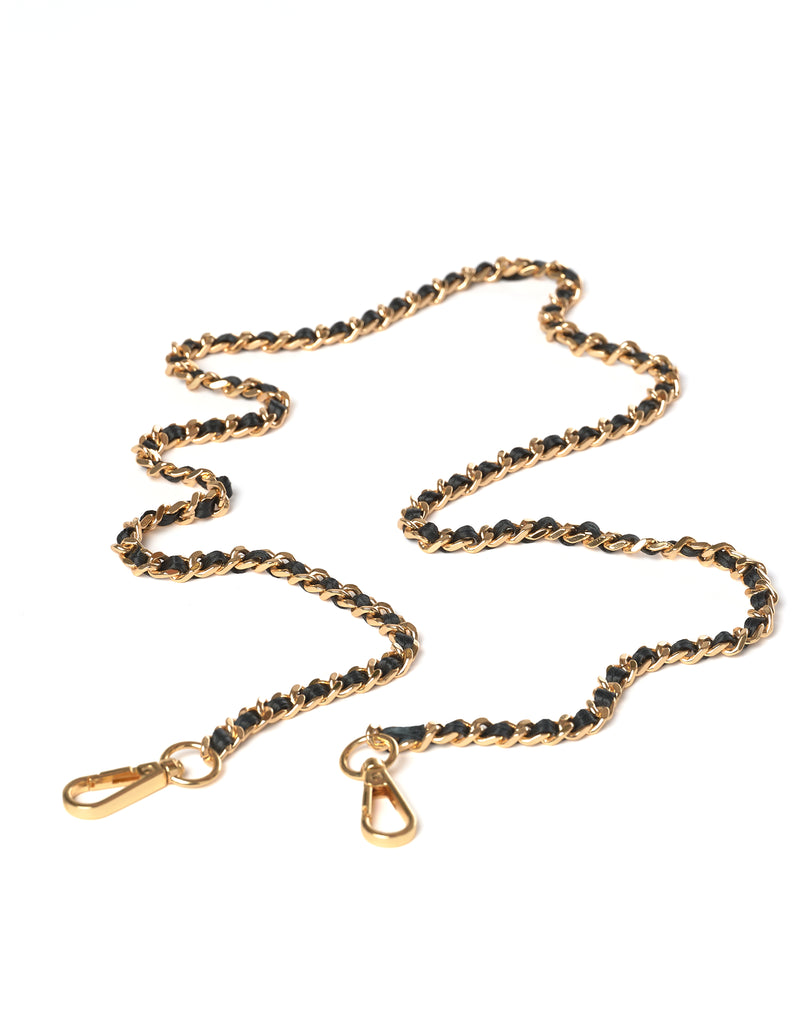 Gold crossbody chain with black leather on a white background