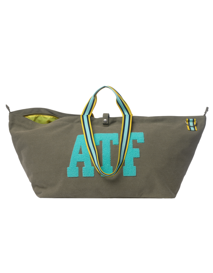 Grote khaki canvas draagtas BROOKLYN met gestreepte hengsels en een kleurrijke patch, een hoogwaardig modeaccessoire.