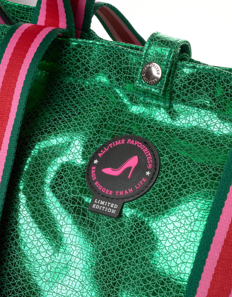 Close-up of the Tote Bag Venezia in metallic green croc print with striped pink and red handles and All-time Favourites limited edition logo badge.