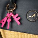 Black tote bag in vegan leather and beige straw with gold logo and pink ATF letter keychain