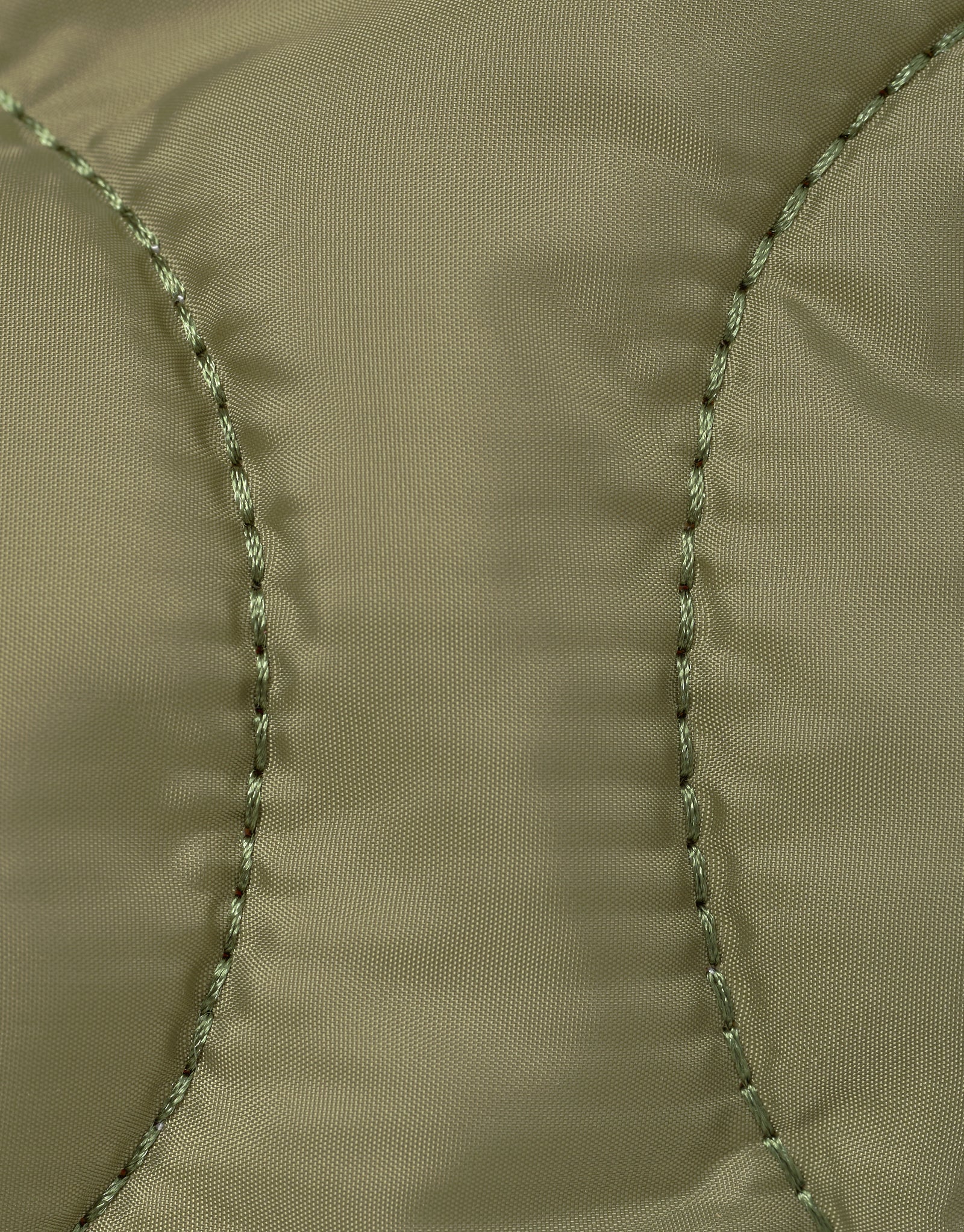Close-up of arme green nylon fabric with stitching detail