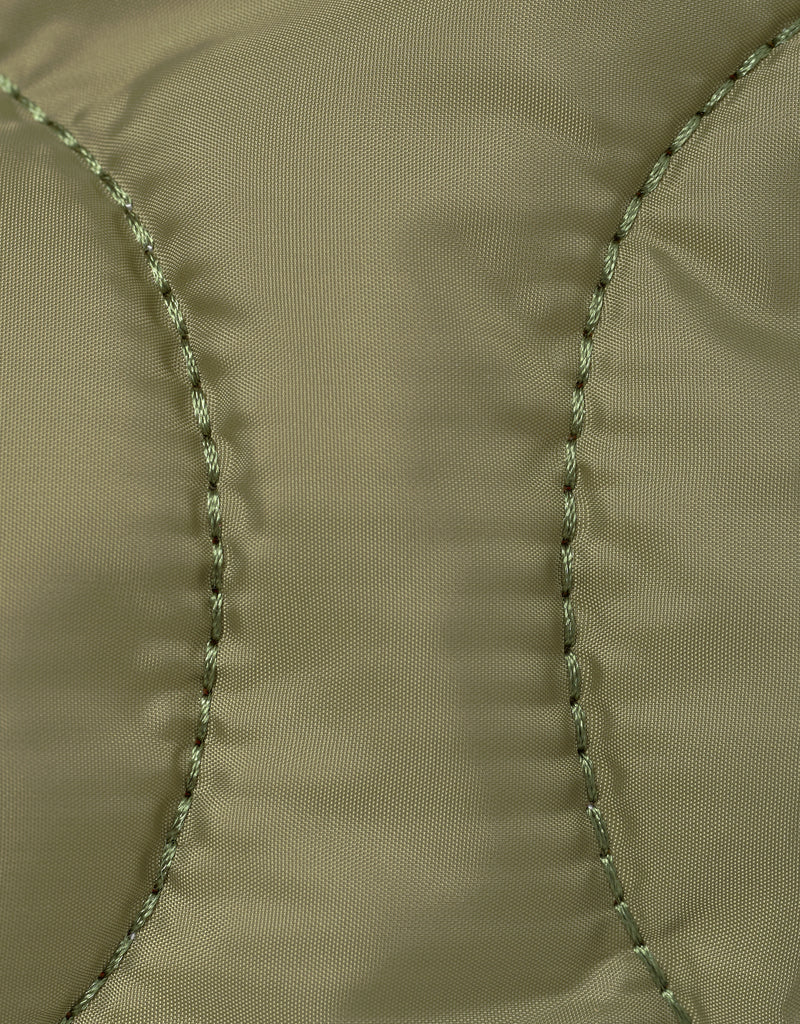 Close-up of arme green nylon fabric with stitching detail