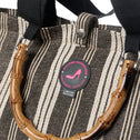 Close-up detail of the Tote Bag Galle in black and white stripe with bamboo handle, black shoulder straps and All-time Favourites limited edition logo badge.