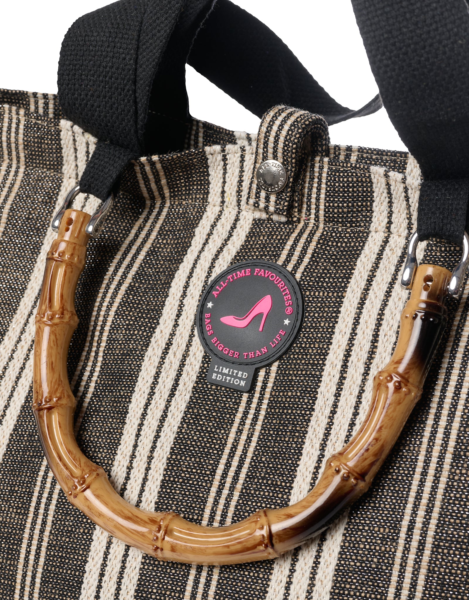 Close-up detail of the Tote Bag Galle in black and white stripe with bamboo handle, black shoulder straps and All-time Favourites limited edition logo badge.