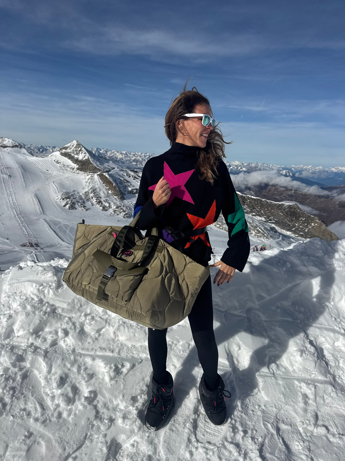 Woman in star sweater on snowy mountain holding green puffy large tote bag, All-time Favourites DIANA.