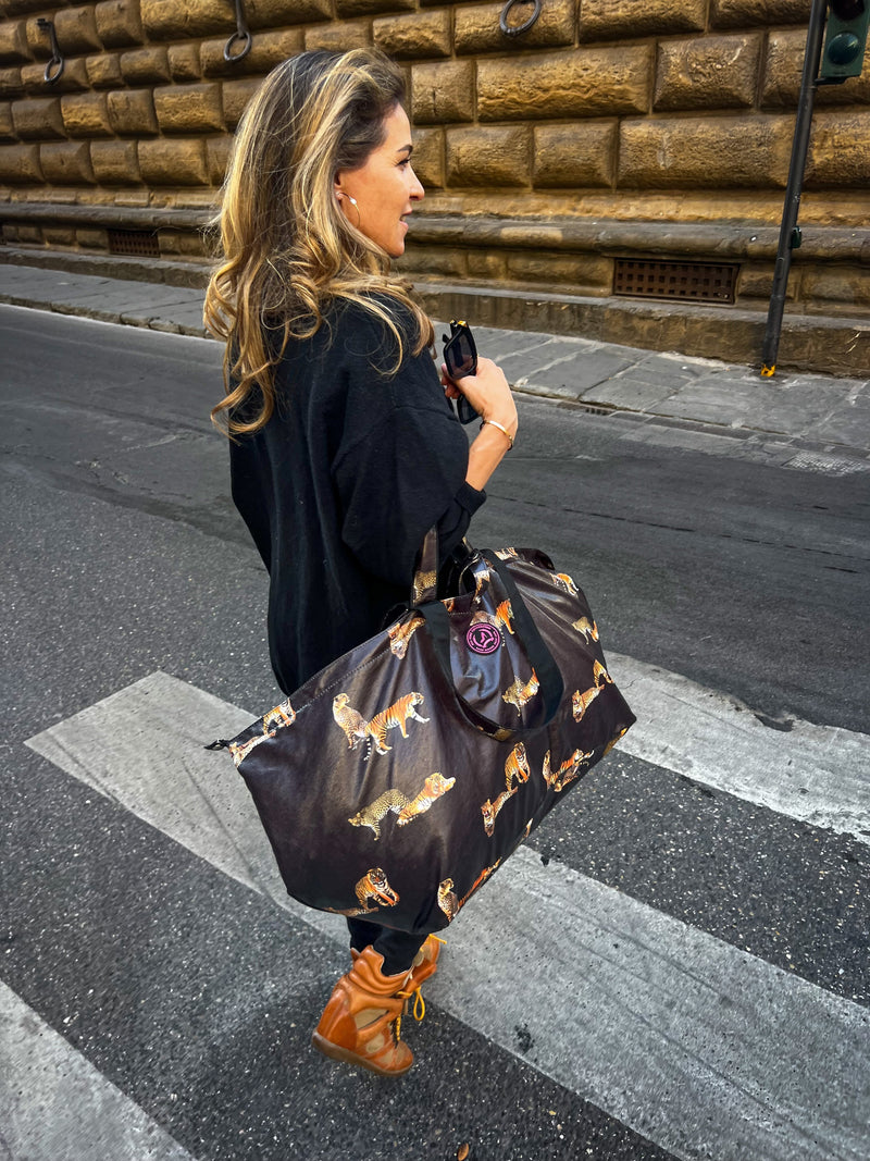 Brechje met grote zwarte shopper met tijgerprint lopend op zebrapad