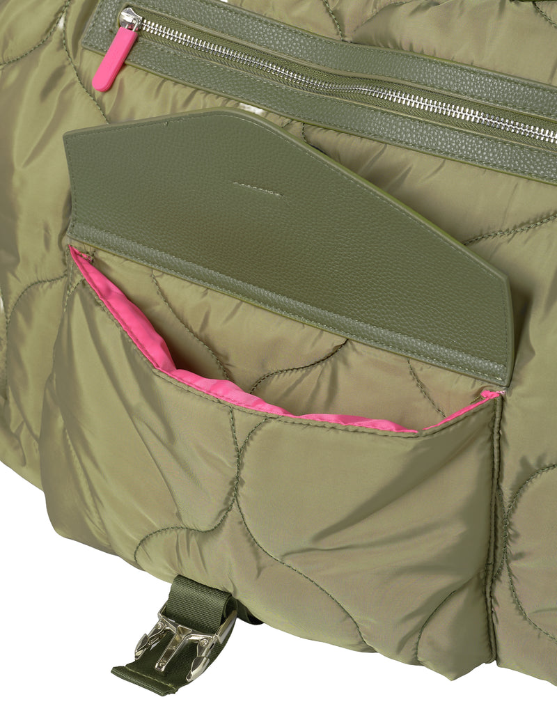 Close-up of a green quilted bag with pink interior a kangaroo pocket and visible buckle.