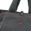 Close-up detail large grey teddy tote bag with black canvas and metal button, visible logo badge