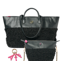 A black tote bag with a textured sherpa-style lower half, dual top handles, a small matching pouch with a gold chain strap, and a pink keychain charm, shown on a plain white background.