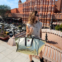 Woman holding a large gold handbag in front of Hawa Mahal in Jaipur, India