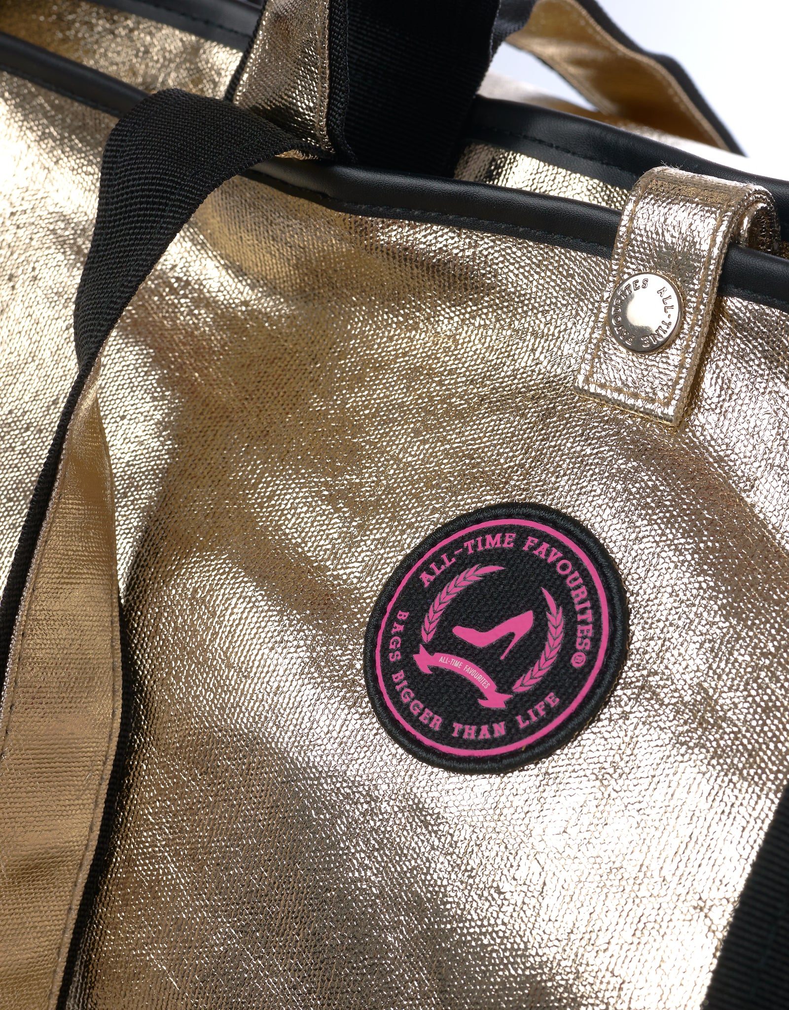 Detail of Jaipur Tote Bag with champagne gold coated cotton, black webbing handles and round All-time Favourites logo