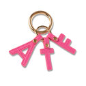 Pink vegan leather keychain with gold ring, featuring A, T, E letter charms; premium fashion accessory.