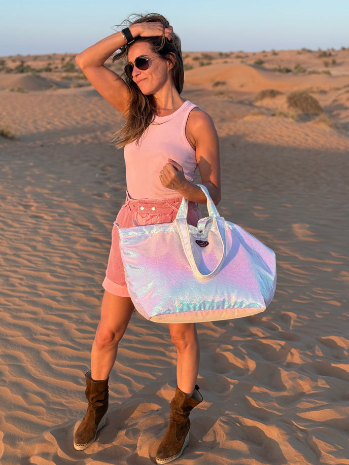 Woman in a desert setting holding a iridescent tote bag