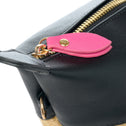 Zipper detail with pink puller on black vegan leather and beige straw bag