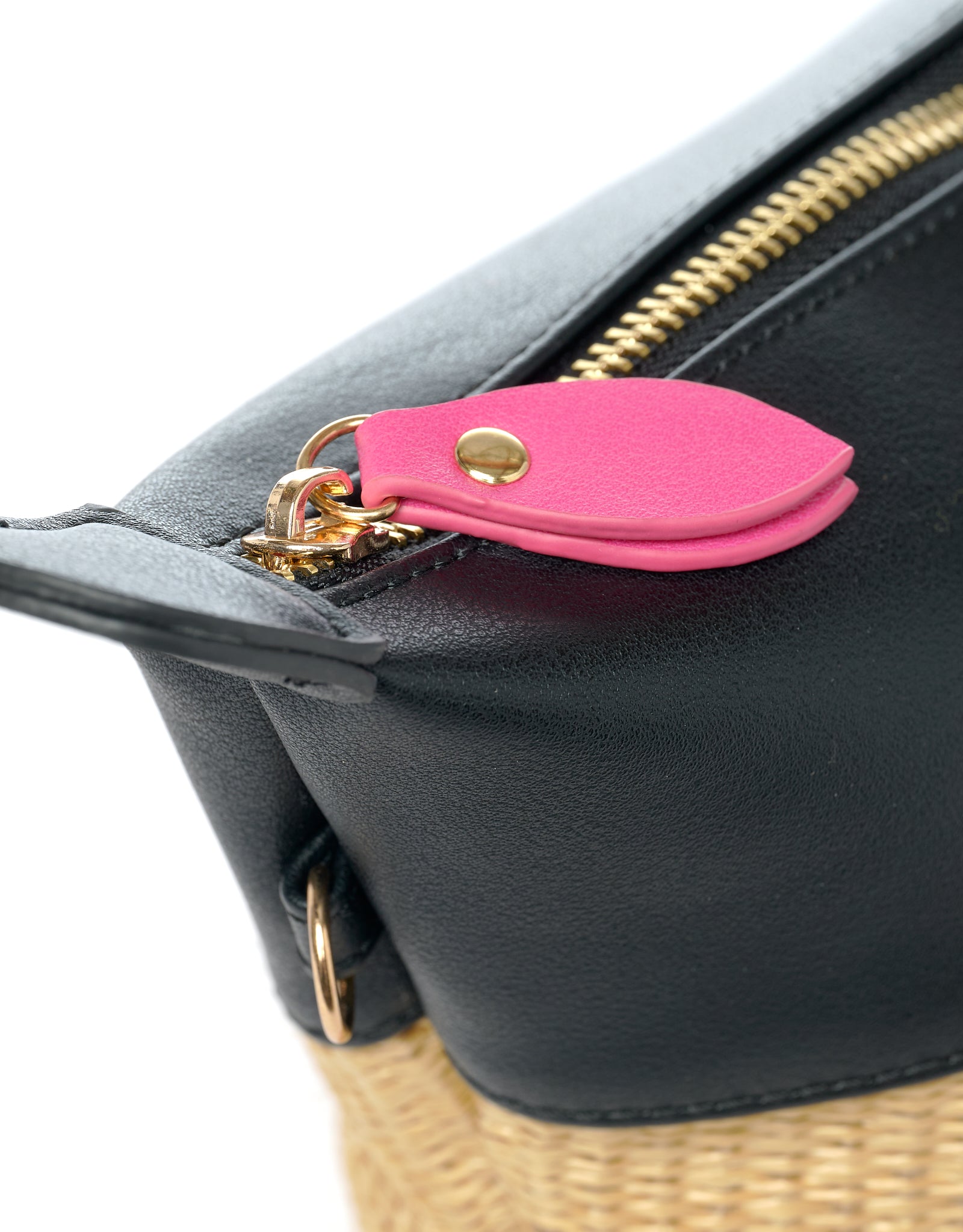 Zipper detail with pink puller on black vegan leather and beige straw bag