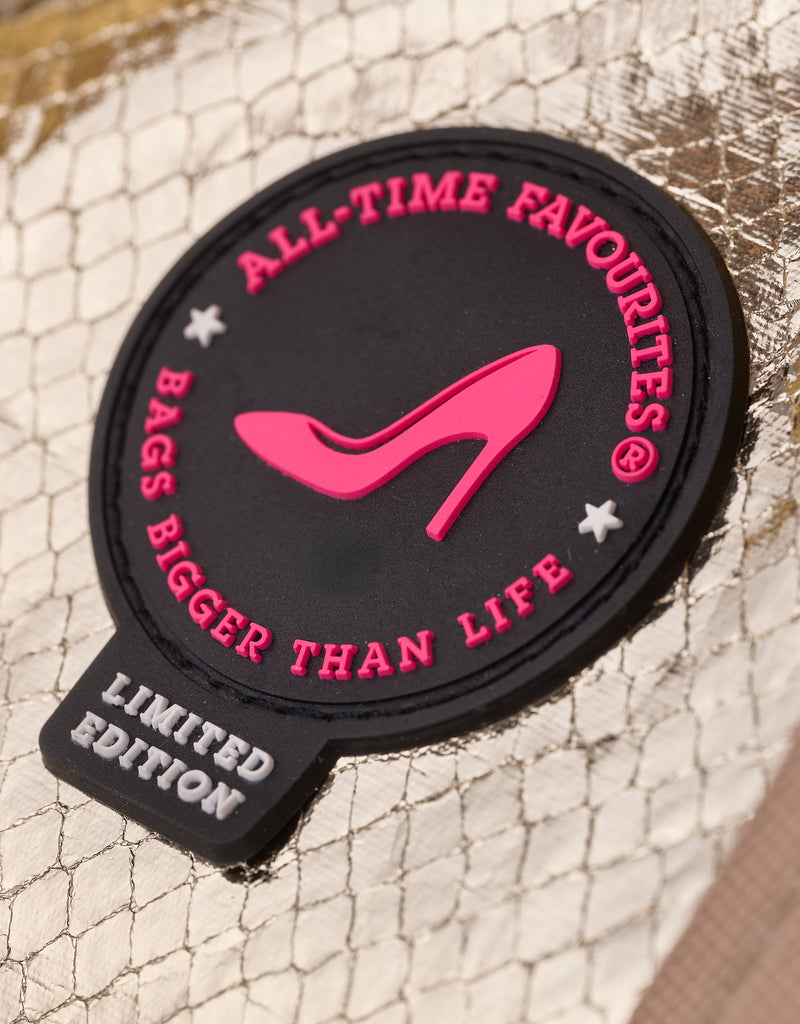 Close-up of the All-time Favourites pink heel logo on a gold metallic python print tote bag