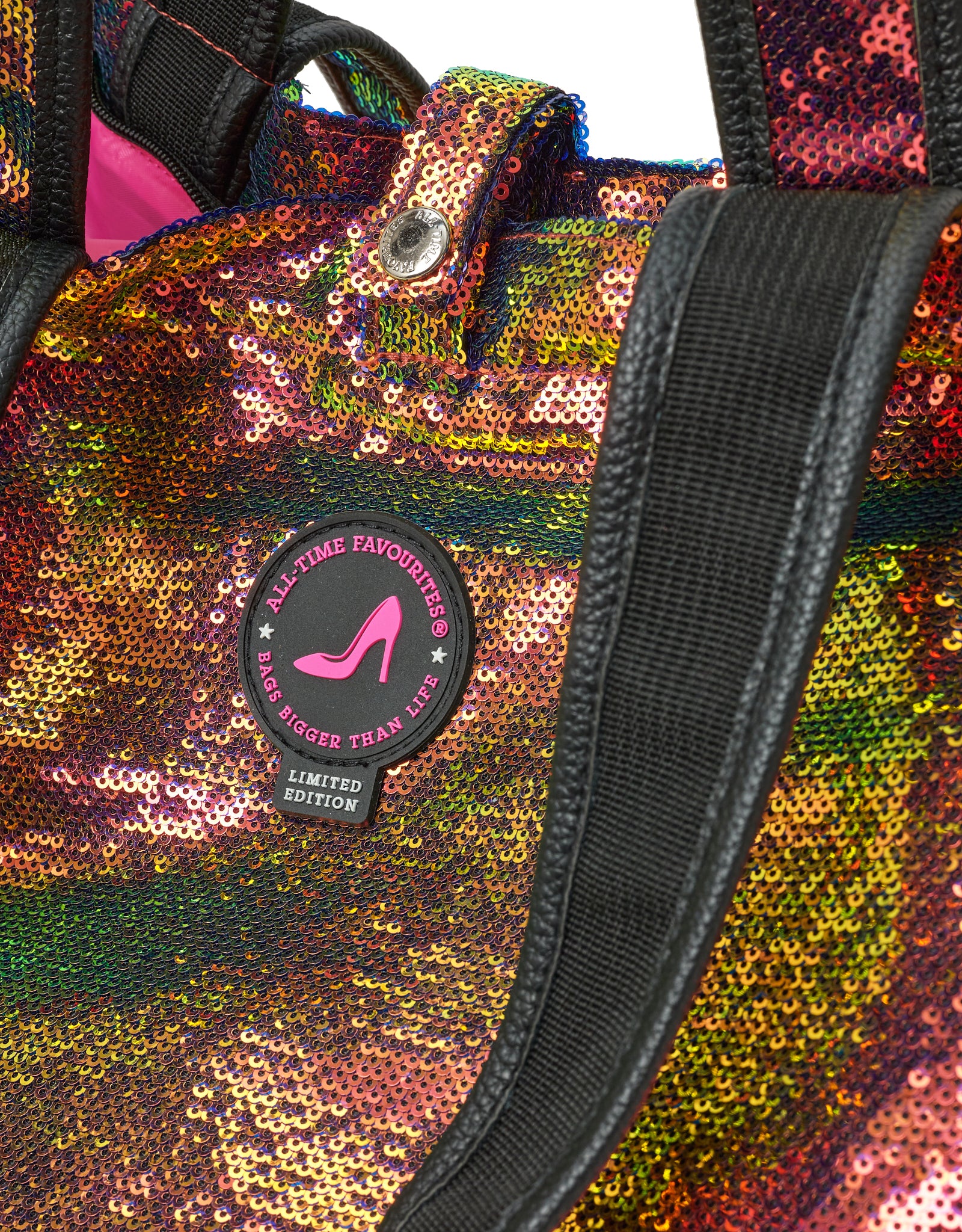 Multicolored sequin bag with black handles a pink and black patch featuring a pink high heel shoe.