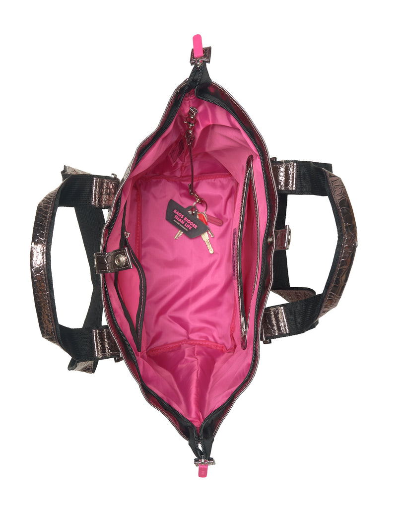 Pink lining of hand bag with black and shiny bronze straps on a white background