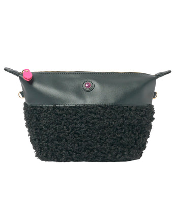 Zwarte clutch van imitatieschapenvacht met ritssluiting, roze bedeltje, veganistisch materiaal en dubbele handvatten.