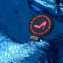 Blue textured surface with a 'All-Time Favourites' patch featuring a pink high heel.