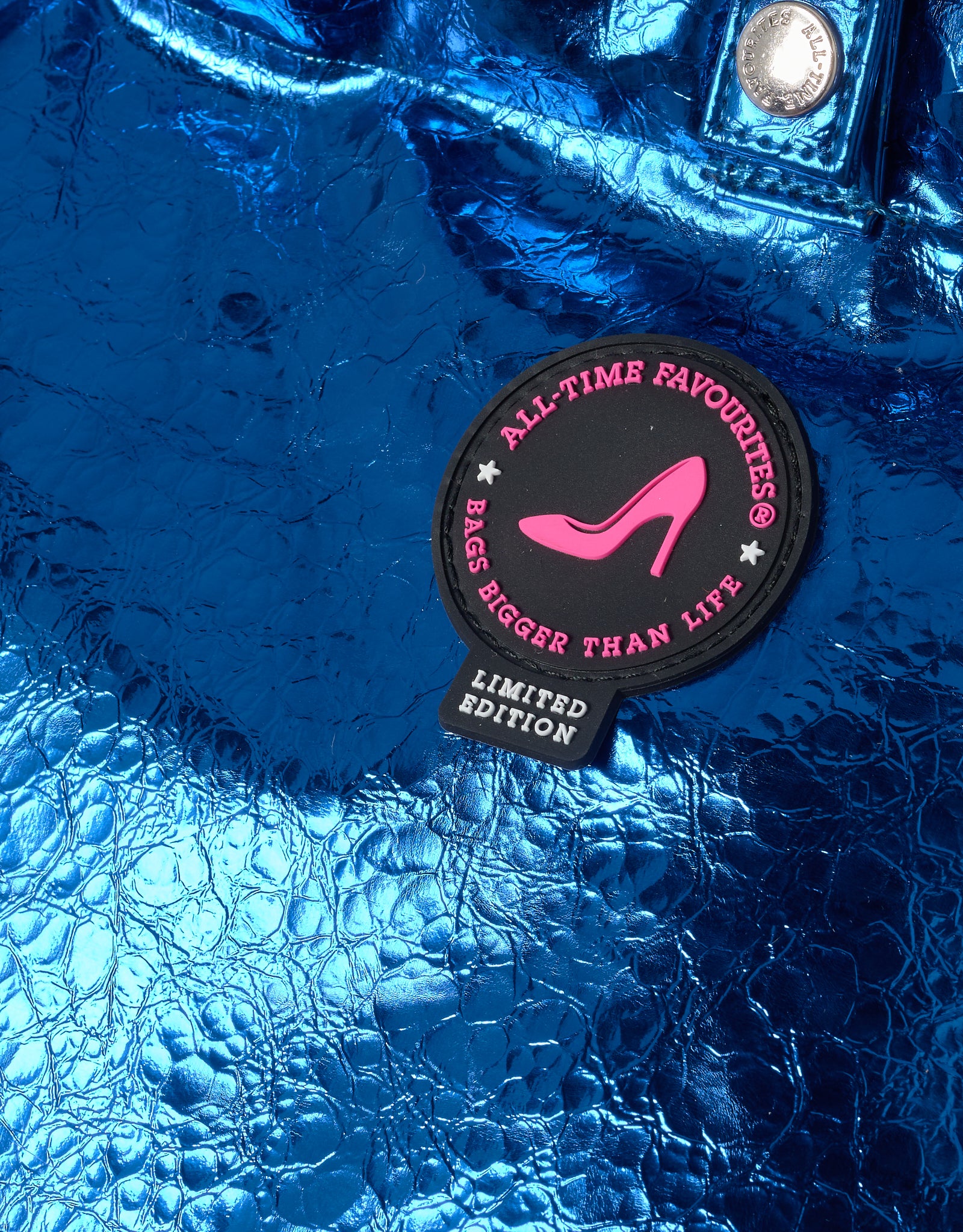 Blue textured surface with a 'All-Time Favourites' patch featuring a pink high heel.