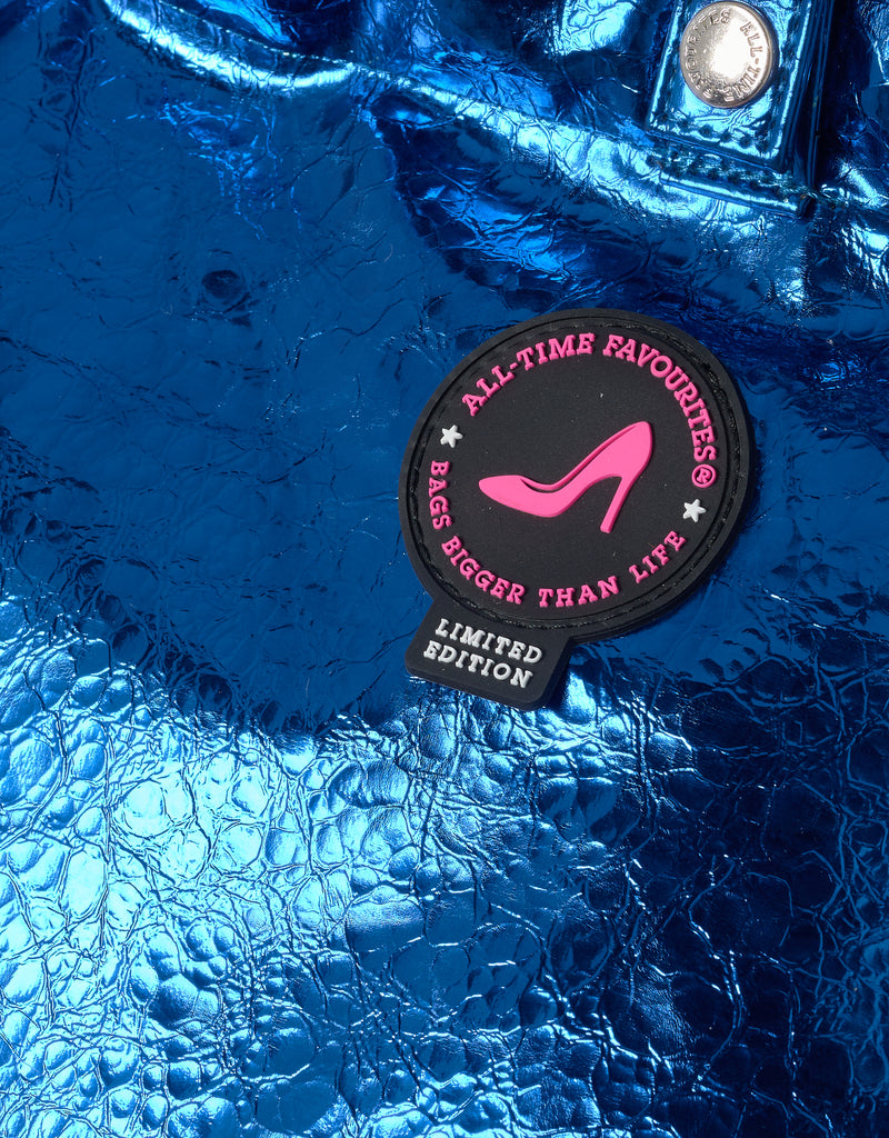 Blue textured surface with a 'All-Time Favourites' patch featuring a pink high heel.