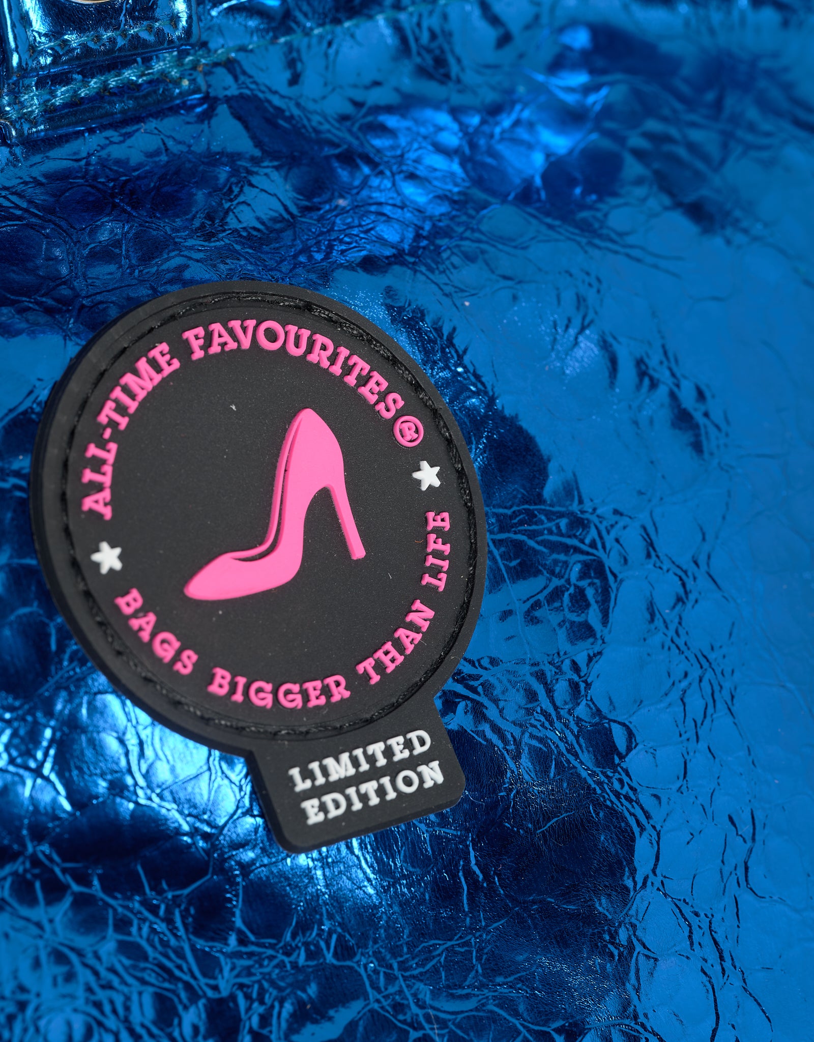 Patch with 'All Time Favourites' branding on a blue textured background