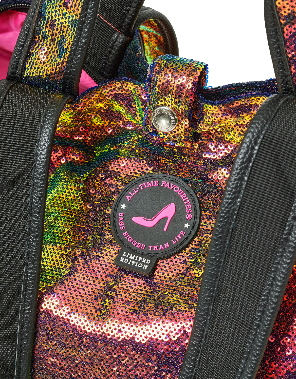 Small tote bag with multi-colour sequins, black straps, and round pink limited edition label.