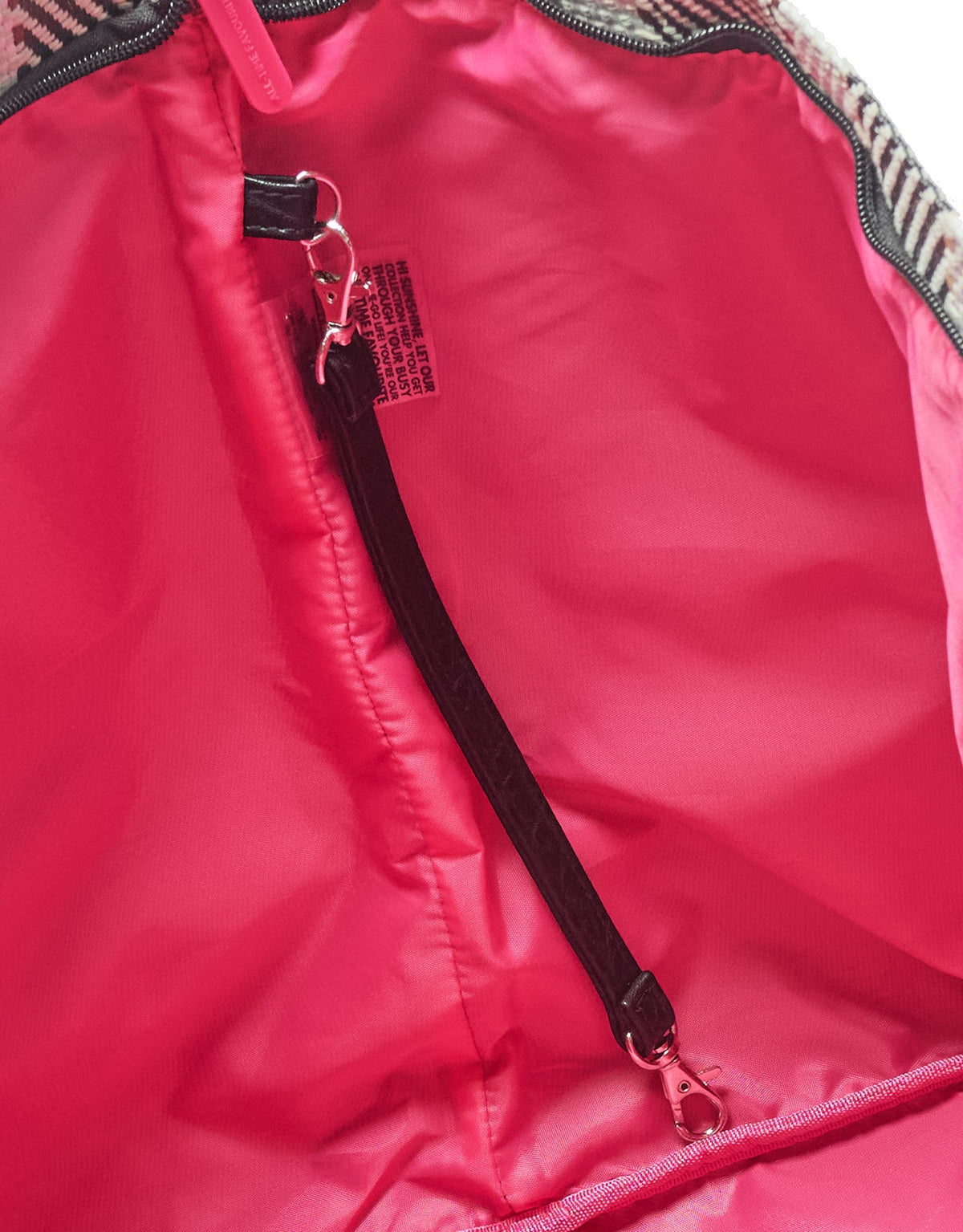 Close-up of the inside of the black croc print tote bag shows a black zippered pocket, interior strap with key clip, bright pink lining, and fabric tag. The lining features an additional zippered compartment.