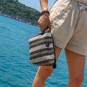 Person holding a striped All-time Favourites toiletry bag 
