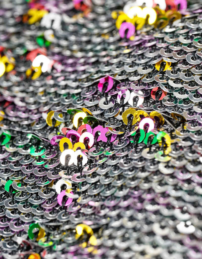 Close-up of colorful sequins with a mix of silver, pink, yellow, and green.
