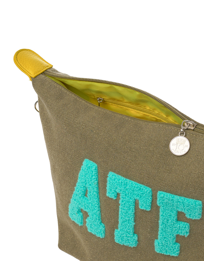 Close-up of ATF canvas toiletry bag with zipper, coin charm and yellow lining