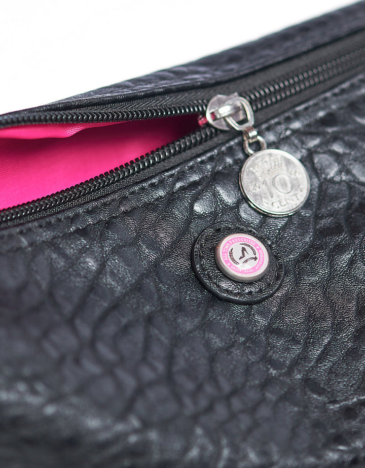 Schwarze Kulturtasche mit Krokodil-Print, Reißverschluss, rosa Futter und Münz-Detail an der Reißverschlusslasche.