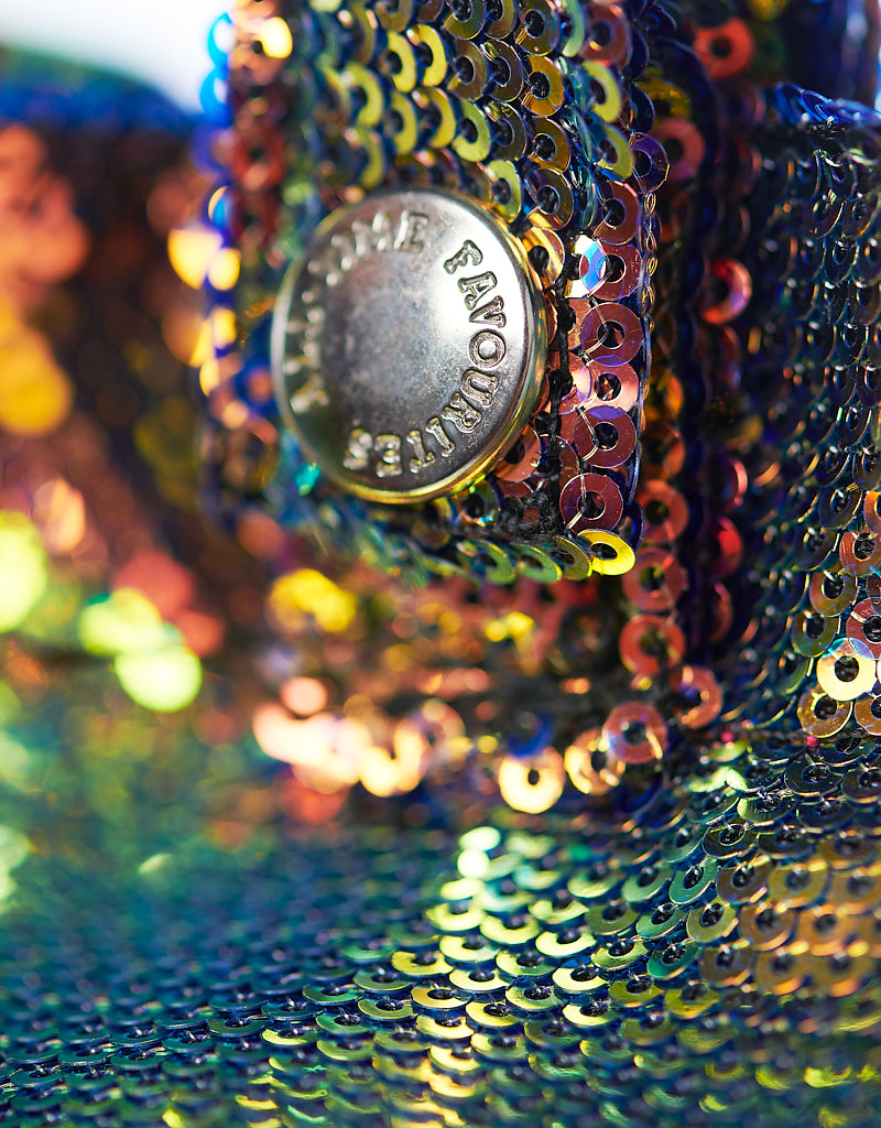Close-up van een metalen knoop op de ‘All-time Favourites Large’-draagtas van veelkleurige paillettenstof, IBIZA-ontwerp.